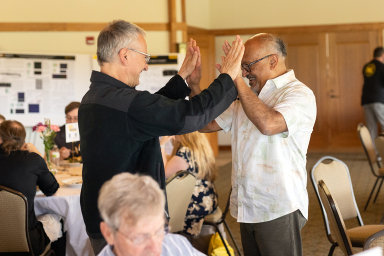 Debashish Bhattacharya clasping hands in celebration with former colleague